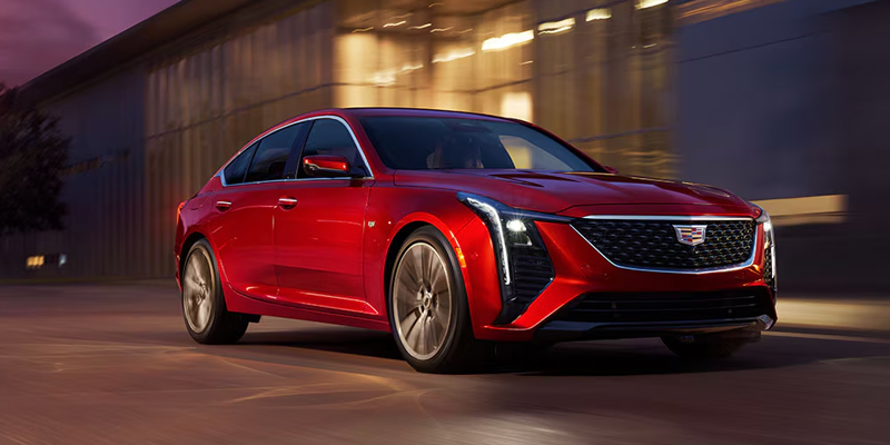Cadillac CT4 sedan driving on city street at night
